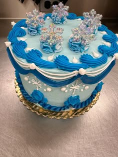 a blue and white frosted cake with snowflakes on top