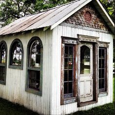 an old white building with arched windows and a tin roof