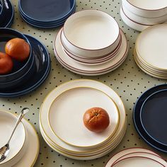 a table topped with plates and bowls filled with oranges on top of each plate