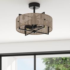 a ceiling light that has a wicker basket on it and is hanging from the ceiling