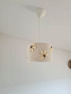 a light fixture hanging from the ceiling in a room with white walls and flooring