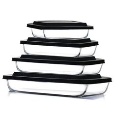 four glass casserole dishes stacked on top of each other with black lids and handles