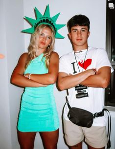 a man and woman dressed up as the statue of liberty, one holding his arms crossed