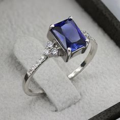 An impressive radiant cut Sapphire brings rich color to this ring, contrasted by brilliant diamond side stones set in a shimmering 10,14 or 18 Karat gold setting.- Made to Order, Perfectly finished, Fast shipping fully insured and trackable online.- Gemstone info: Sapphire corundum 8x6 mm, Excellent cut, 1.54 ct- Diamond info: 16 x Diamonds ranging from 1-1.75mm, VS-E, 0.15 ctw- Arrives gift ready with a certificate of authenticity Radiant Cut Sapphire Ring For Formal Occasions, Luxury Diamond Ring With Rectangular Stone, Luxury Diamond Ring With Rectangular Stone For Anniversary, Rectangular Brilliant Cut Diamond Ring For Gift, Rectangular Brilliant Cut Diamond Ring Gift, Brilliant Cut Rectangular Diamond Ring As A Gift, Rectangular Brilliant Cut Diamond Ring As A Gift, Elegant Diamond Ring With Rectangular Stone, Formal Emerald Cut Cubic Zirconia Birthstone Ring