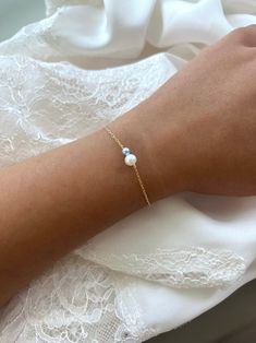 a woman's arm wearing a bracelet with pearls