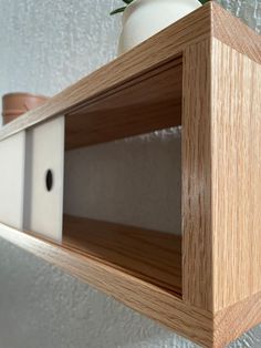 a wooden shelf with a white vase on top