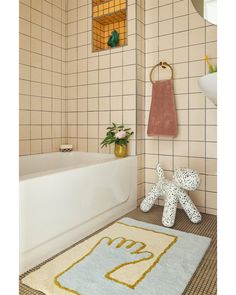 a bathroom with a rug, bath mat and towel on the floor in front of it