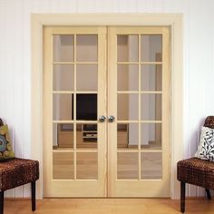 two chairs sitting in front of an open glass door to a living room with white walls and wood floors