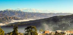 the mountains are covered in fog and low lying clouds