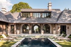 a large house with a pool in front of it and lots of windows on the roof