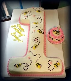 a cake shaped like the number one with bees on it