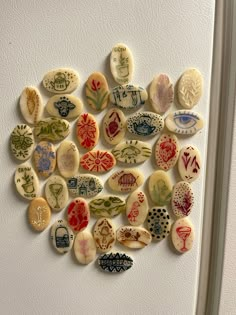 a bunch of different types of buttons on a white wall in the shape of a heart