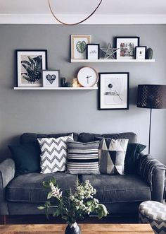 a living room filled with furniture and framed pictures on the wall above it's coffee table