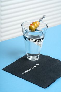 there is a small glass with an olive in it