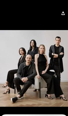 a group of people sitting next to each other on a white chair in front of a wall