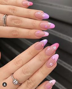 a woman's hands with pink and white nail polish