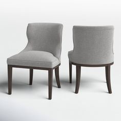 two gray chairs sitting next to each other on a white surface with no one in it