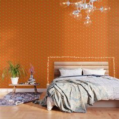 a bedroom with red wallpaper and a chandelier hanging from the ceiling above it