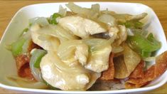 a white bowl filled with food on top of a wooden table