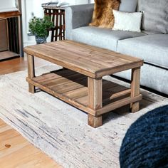 a living room with a couch, coffee table and rug on the floor in front of it