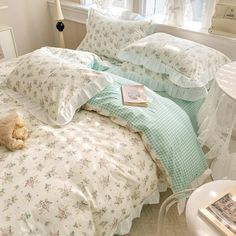 there is a teddy bear sitting on the bed in this room with many pillows and sheets