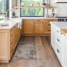 a kitchen filled with lots of wooden cabinets and counter top space next to a window