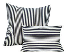 two blue and white striped pillows sitting next to each other