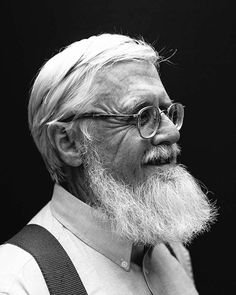 black and white photograph of an older man with glasses looking off to the side, wearing suspenders