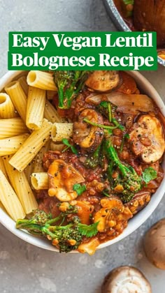 a white bowl filled with pasta, mushrooms and broccoli on top of a table