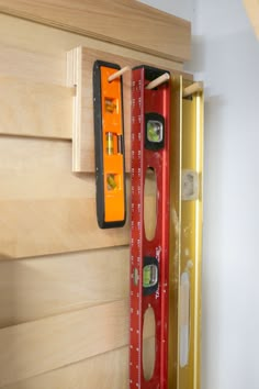 a pair of measuring tools hanging on the side of a wooden wall next to a window