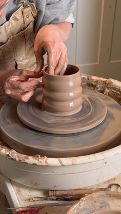 a woman is making a pot on a potter's wheel