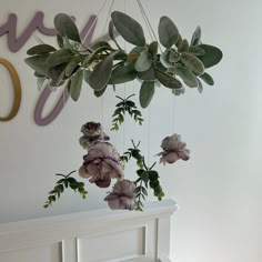 flowers hanging from the ceiling in front of a wall