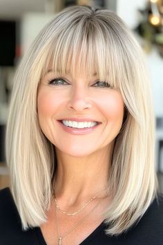 Save this pin for the best medium-length haircuts for women over 60 with bangs. This blonde lob sits perfectly at the collarbone and has wispy bangs that have a lightness that softens the look. This style lets your natural texture peek through while maintaining a refined shape. Blonde Lob With Side Bangs, Medium Length Side Part With Bangs, Shoulder Bob With Side Bangs, Medium Length Angled Bob With Bangs, Medium Layered Haircuts With Wispy Bangs, Womens Shoulder Length Hair With Bangs, Medium Choppy Bob With Bangs, Short Bangs Long Hair Layered Cuts, Medium Length Hair For Oval Face