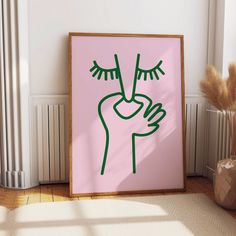 a pink poster with green hand drawn on it in front of a white radiator