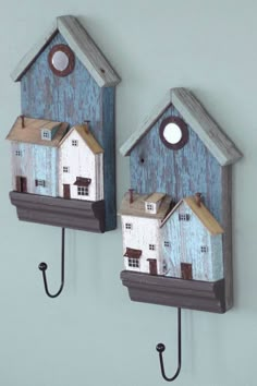 two birdhouses are hanging on the wall