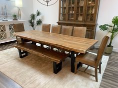 a dining room table with two benches in front of it and an area rug on the floor