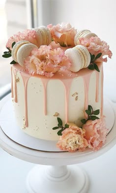 a white cake with pink flowers and shells on top