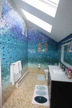 a bathroom with blue and green tiles on the walls