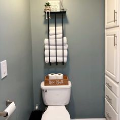 a white toilet sitting in a bathroom under a towel rack