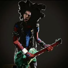 a man with dreadlocks holding a green and red electric guitar in front of a black background