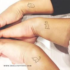 two people with matching tattoos on their arms, one holding the other's hand