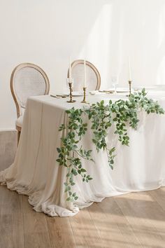 the table is covered with greenery and candles