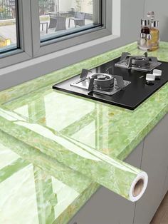 a green counter top in a kitchen next to a window