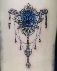 a woman's thigh with a blue diamond and chain tattoo on the side of her leg