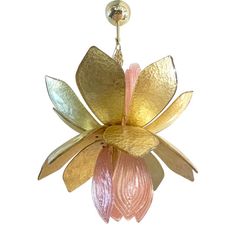 a gold and pink flower hanging from a hook