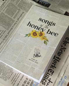 an open newspaper with the words songs of the honey bee on it and sunflowers