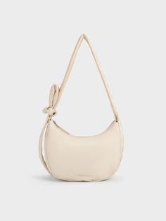 Featuring a cute and casual design, the Delilah hobo bag is the perfect everyday companion. Its minimalist design lets its soft puffy texture shine -- the versatile oat finish adds to its charm. Opening up to a spacious interior, you will be able to fit more than the essentials while the knotted strap allows you to adjust the bag to a comfortable drop length. Casual Cream Shoulder Baguette Bag, Casual Cream Baguette Shoulder Bag, Beige Hobo Bag With Zipper Closure, Casual Cream Baguette Bag For Daily Use, Beige Shoulder Bag With Soft Interior For Daily Use, Casual Everyday Baguette Bag With Adjustable Handle, Versatile Beige Hobo Bag With Adjustable Handle, Casual Cream Baguette Bag For Everyday, Chic Beige Hobo Bag For Spring