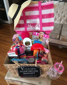 a basket filled with lots of items sitting on top of a wooden floor next to a pink bag