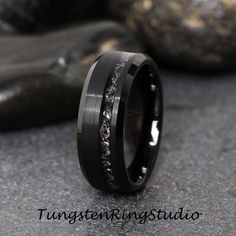 a wedding band with black and white diamonds inlayed to the inside of it