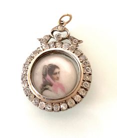 Antique Edwardian Silver 925 Bow design Locket with a gold wash over colour and surrounding glass paste gem stones all gem stones are original and secure as well as in unusually excellent condition - very clean . Locket holds a miniature hand painted ? image on porcelain inside of a young woman with pink scarf - with the stamp mark "5" on its reverse. Diameter of locket is approx 2.5 cm The open jump ring is 18ct Gold This is not marked for silver but has a pawnbrokers details etched on one side Antique Jeweled Silver Jewelry, Antique Silver Jeweled Jewelry, Oval Diamond Jeweled Jewelry, Oval Diamond Jewelry With Jeweled Details, Antique Jeweled Jewelry, Ornate Collectible Diamond Jewelry, Antique Collectible Jewelry With Stone Setting, Ornate Diamond Jewelry Collectible, Ornate Diamond Jewelry For Collectors